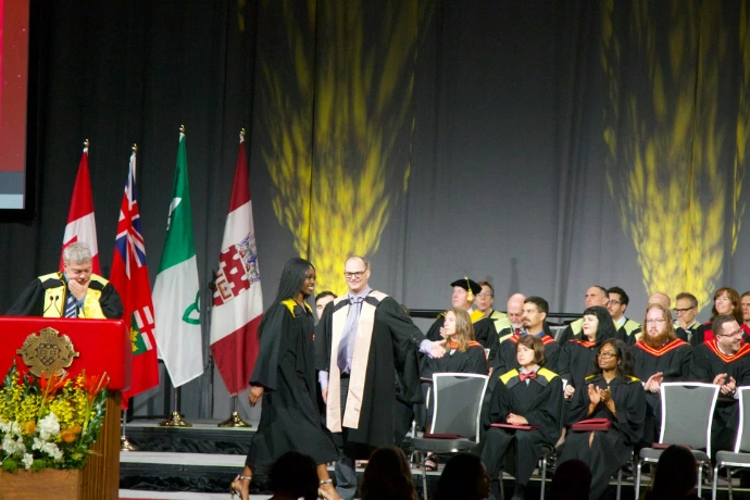 woman wearing black academic gown on stage